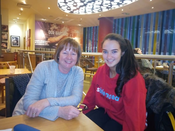 Photo of mentor Janet and mentee Lydia posing and smiling in cafe